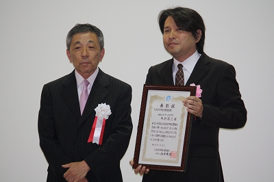 大阪府印刷工業組合賞（左から西井理事長、受賞者の木村さん）